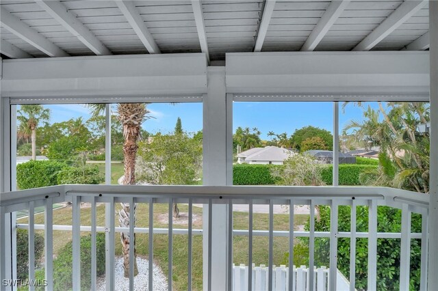 unfurnished sunroom with beamed ceiling