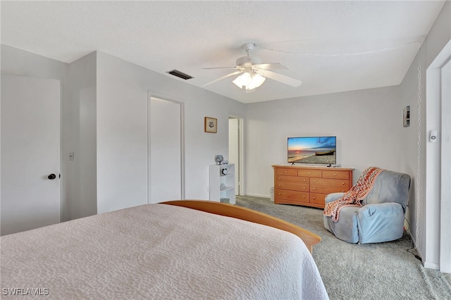 carpeted bedroom featuring a ceiling fan, visible vents, and a textured ceiling