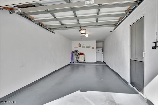 garage with a garage door opener, baseboards, and freestanding refrigerator