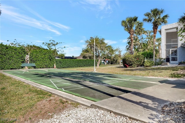 view of property's community with a lawn and shuffleboard