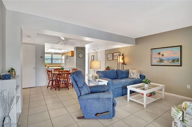 living area featuring light tile patterned floors, visible vents, and baseboards