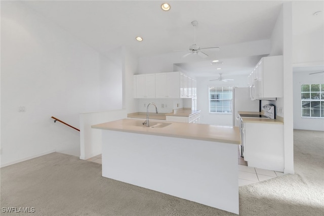 1040 Partridge Cir Unit 201, Naples, FL 34104 - kitchen with sink, range, white cabinetry, light carpet, and kitchen peninsula