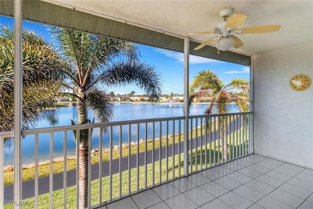 unfurnished sunroom with ceiling fan and a water view