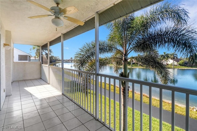 balcony featuring a water view and ceiling fan