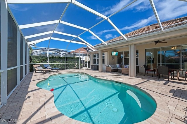 view of swimming pool with ceiling fan, an outdoor living space, a patio area, and glass enclosure