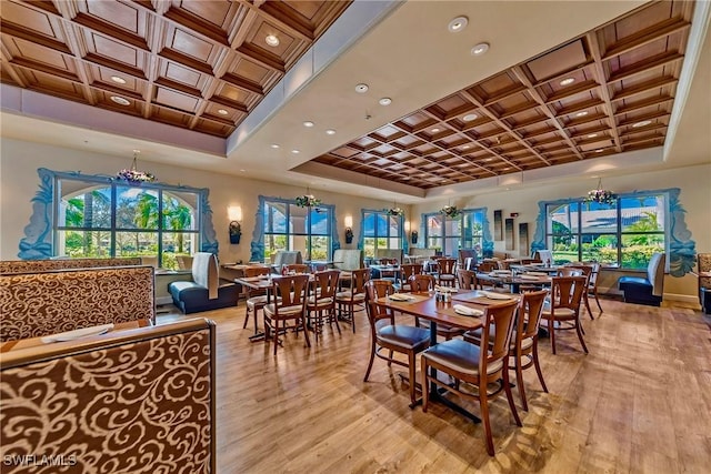 dining room featuring coffered ceiling, a wealth of natural light, and light wood-type flooring