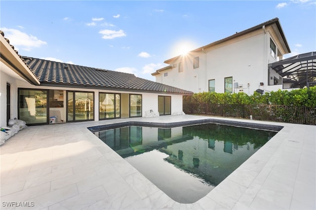 view of swimming pool featuring glass enclosure and a patio area