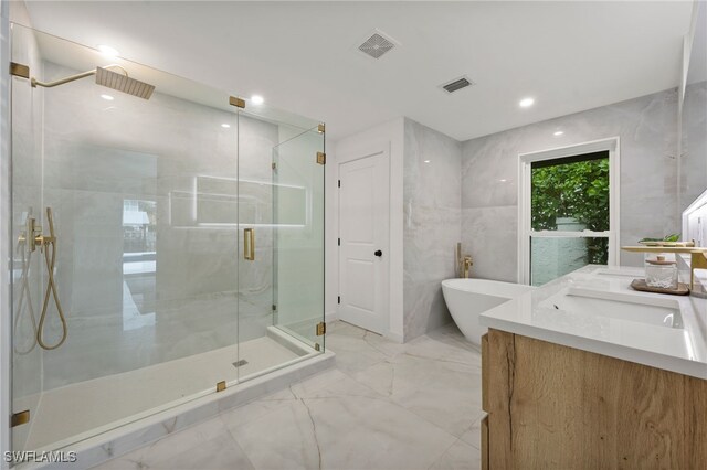 bathroom featuring vanity, separate shower and tub, and tile walls