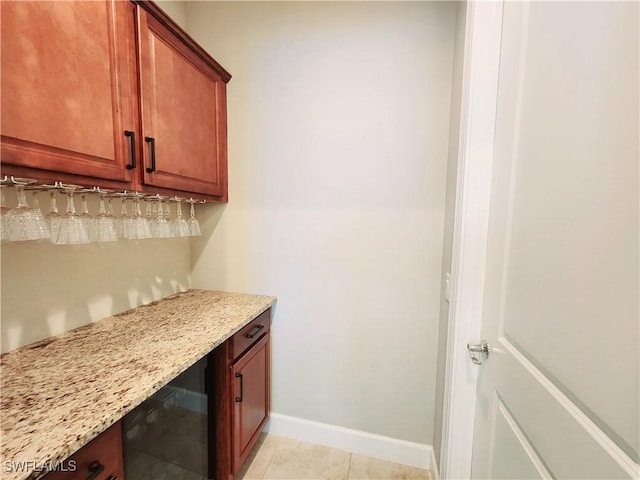 bar with light tile patterned floors and light stone countertops