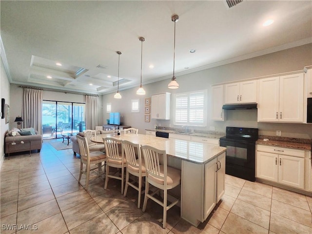 kitchen with black / electric stove, decorative light fixtures, a kitchen island, and white cabinets