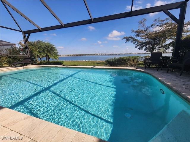 view of swimming pool featuring a water view, a patio area, and a lanai