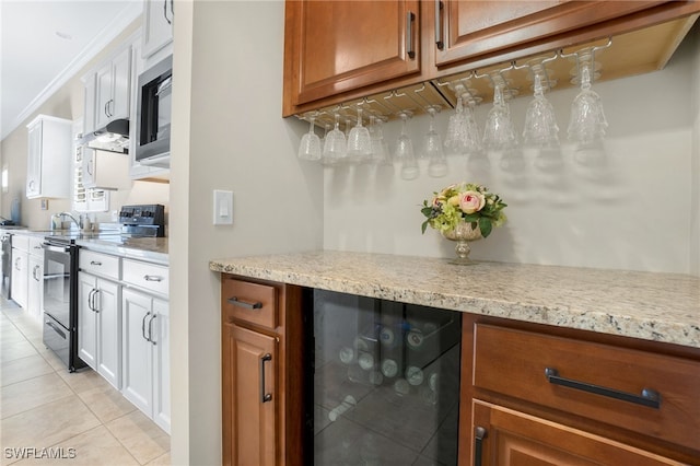 interior space with light tile patterned floors, black range with electric stovetop, wine cooler, ornamental molding, and white cabinets