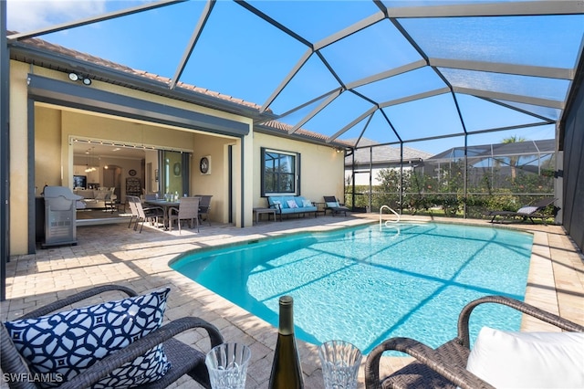 view of pool with a patio area and glass enclosure