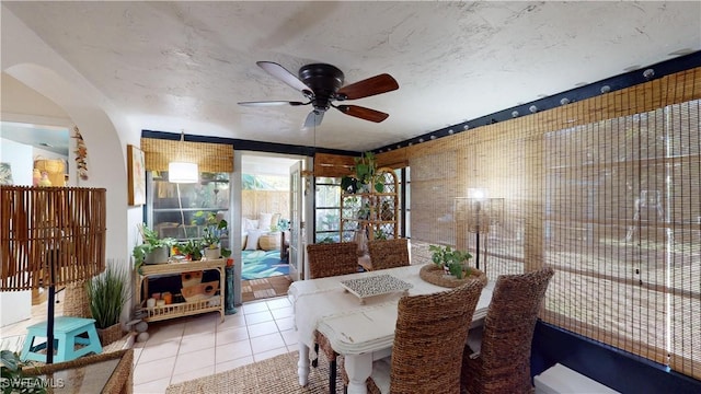 tiled dining space featuring ceiling fan and a textured ceiling