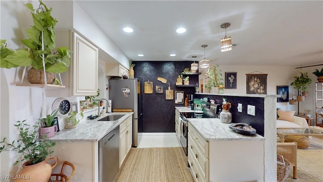 kitchen with stainless steel appliances, hanging light fixtures, sink, and light stone counters