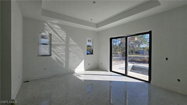 spare room with a tray ceiling