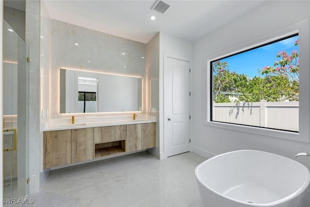 1312 Trail Terrace Dr, Naples, FL 34103 - full bath featuring double vanity, a freestanding tub, a stall shower, healthy amount of natural light, and recessed lighting