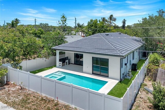 1312 Trail Terrace Dr, Naples, FL 34103 - rear view of property with a patio area, a fenced backyard, a pool with connected hot tub, and stucco siding