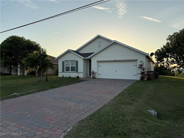 single story home featuring a garage and a lawn