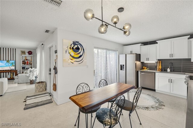 dining area with sink and a textured ceiling