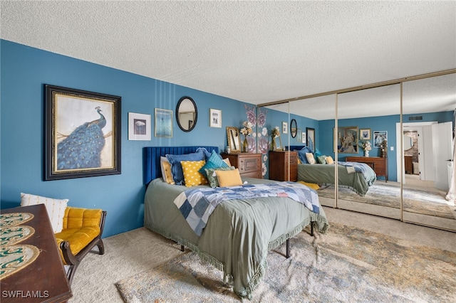 carpeted bedroom with a closet and a textured ceiling