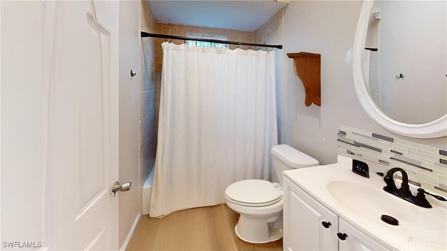 full bathroom with wood-type flooring, backsplash, vanity, shower / tub combo, and toilet