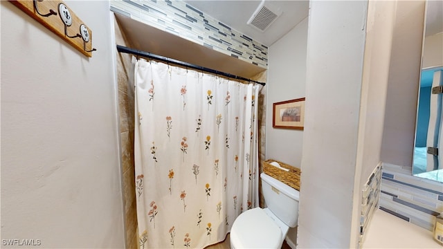 bathroom featuring curtained shower and toilet