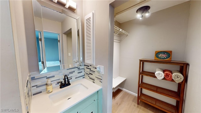 bathroom featuring vanity, hardwood / wood-style floors, and decorative backsplash