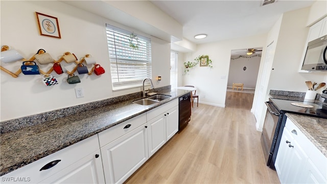 kitchen with sink, light hardwood / wood-style flooring, white cabinets, dark stone counters, and black appliances