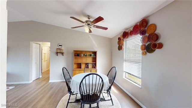 dining room featuring ceiling fan, lofted ceiling, and light wood-type flooring