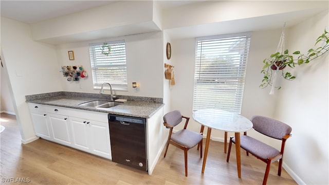 kitchen with sink, light hardwood / wood-style flooring, white cabinets, and black dishwasher