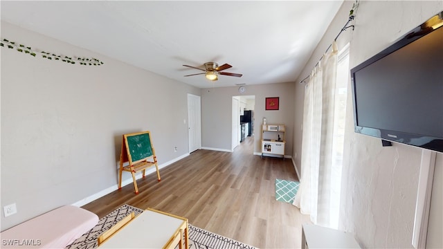 living room with ceiling fan and light wood-type flooring