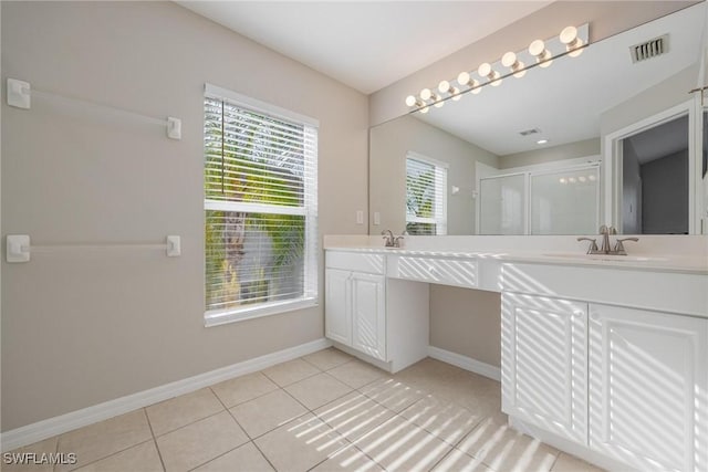 bathroom featuring double vanity, visible vents, baseboards, tile patterned floors, and a sink