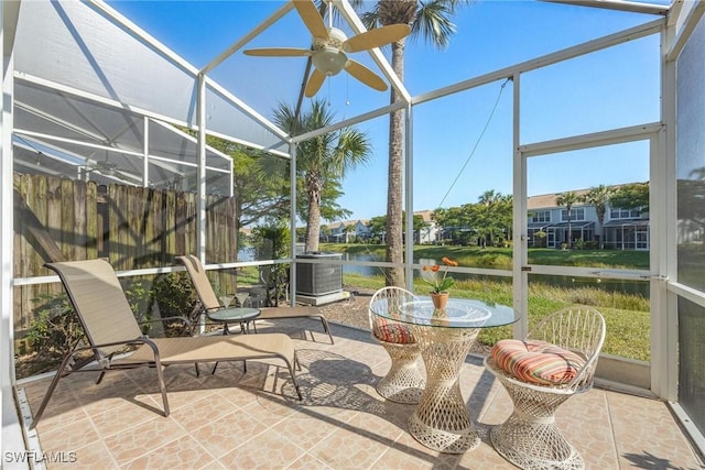 unfurnished sunroom featuring a water view and a ceiling fan