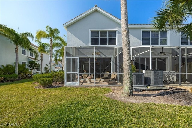 back of property featuring ceiling fan, a patio, central AC unit, a lawn, and stucco siding