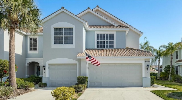 view of front of house featuring driveway, a tiled roof, and stucco siding