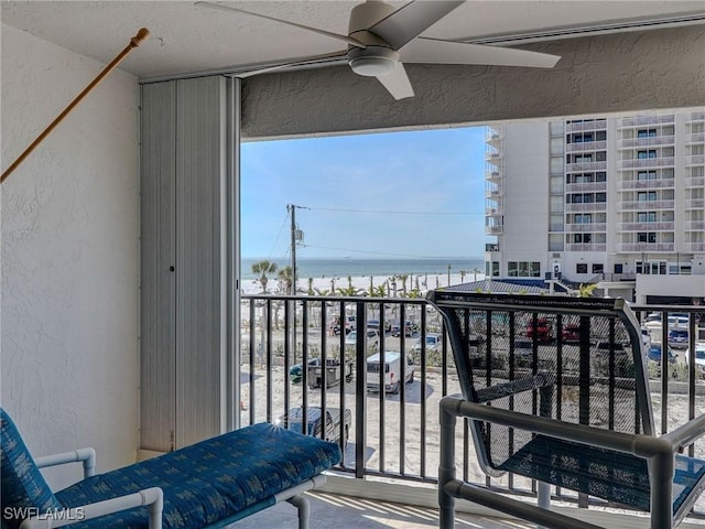 balcony featuring a water view and ceiling fan