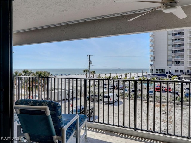 balcony featuring ceiling fan and a water view