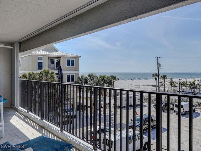 balcony featuring a water view and a view of the beach