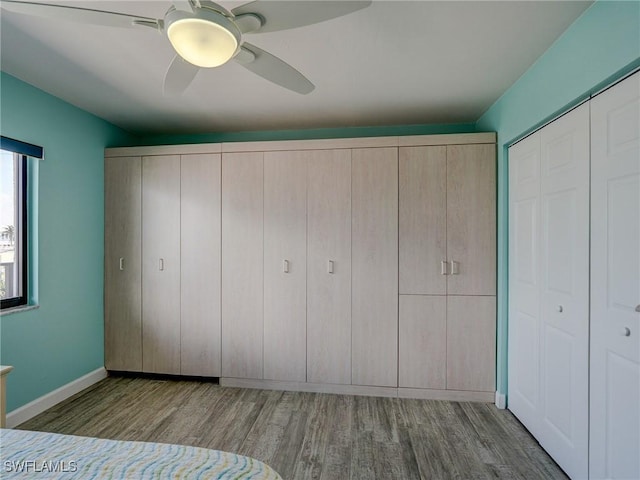 unfurnished bedroom with ceiling fan, a closet, and light wood-type flooring