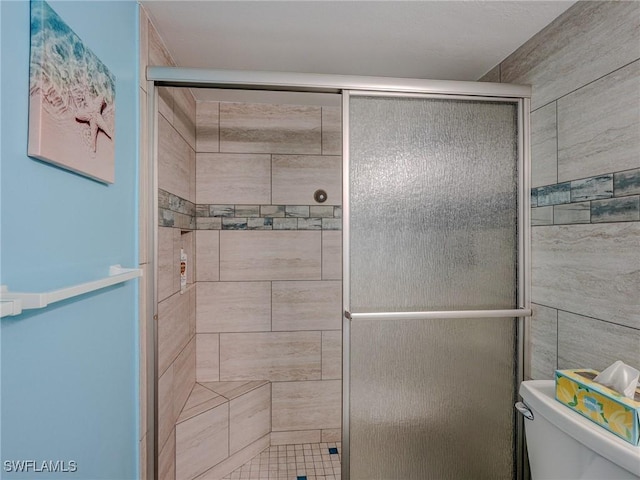 bathroom with toilet and an enclosed shower