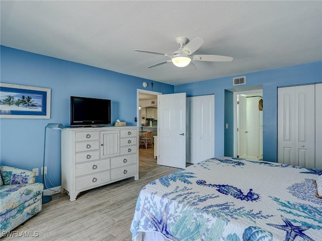 bedroom with multiple closets, ceiling fan, and light wood-type flooring