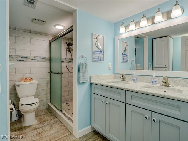 bathroom featuring wood-type flooring, toilet, an enclosed shower, and vanity