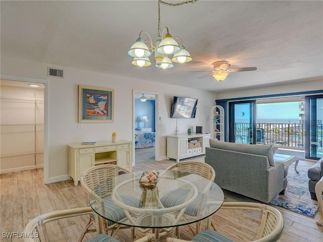 dining area featuring ceiling fan with notable chandelier and light hardwood / wood-style floors