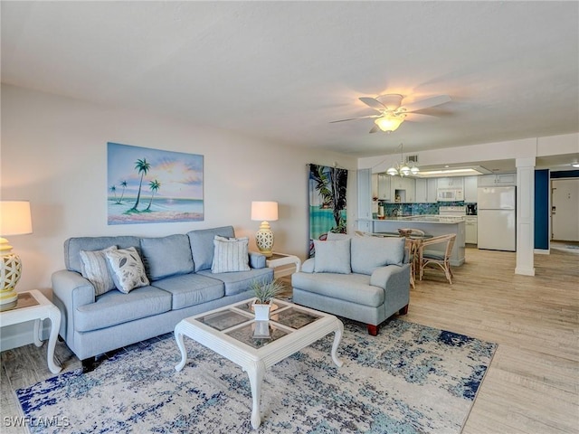 living room featuring ceiling fan and light hardwood / wood-style floors