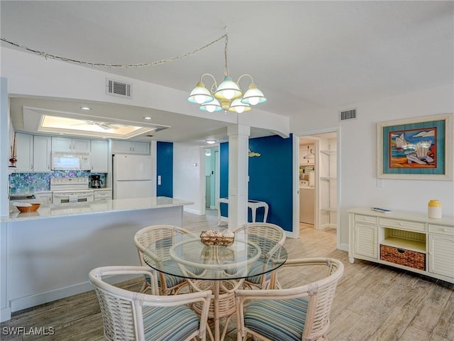 dining space with an inviting chandelier and light hardwood / wood-style floors