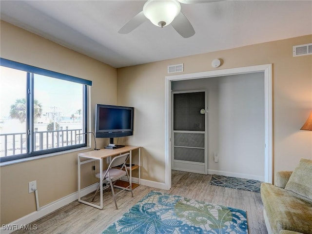 home office featuring ceiling fan and light hardwood / wood-style floors