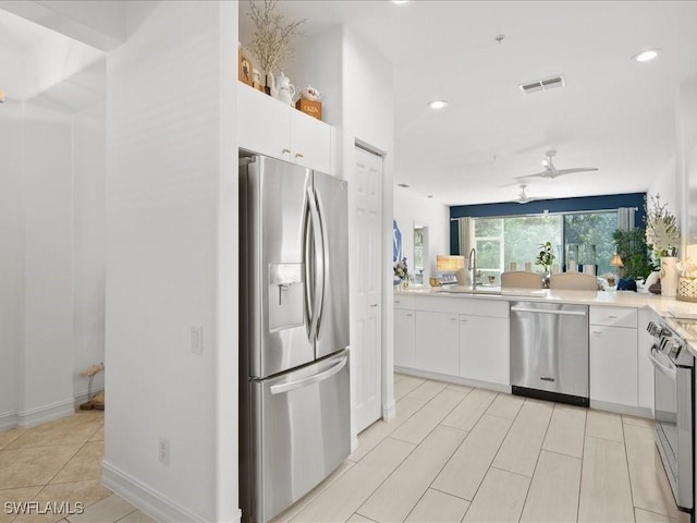 1045 Tarpon Cove Dr Unit 102, Naples, FL 34110 - kitchen with appliances with stainless steel finishes, light countertops, white cabinetry, a ceiling fan, and recessed lighting