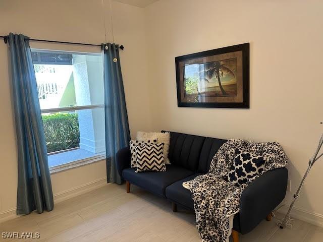 1045 Tarpon Cove Dr Unit 102, Naples, FL 34110 - sitting room with baseboards and wood finished floors