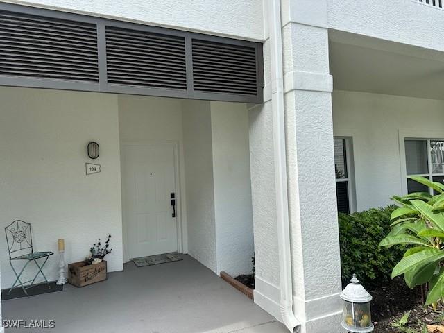 1045 Tarpon Cove Dr Unit 102, Naples, FL 34110 - entrance to property featuring stucco siding